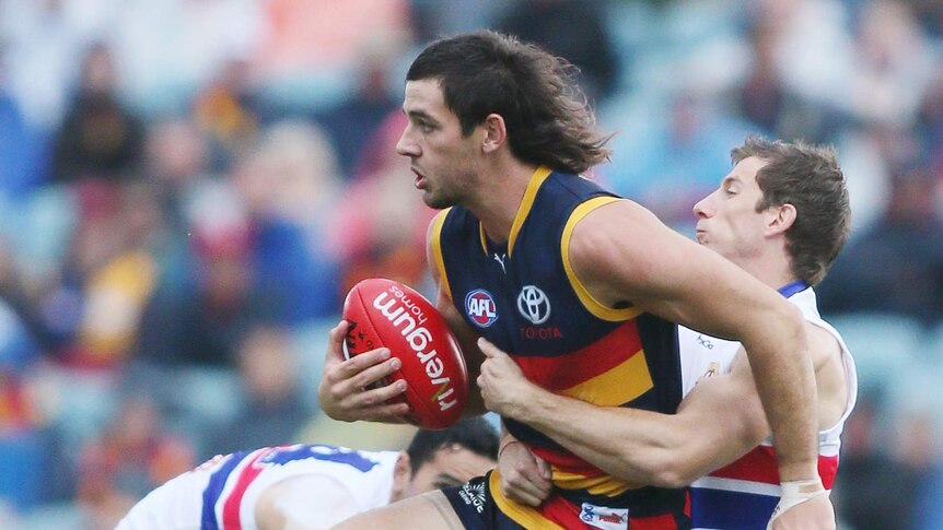 Adelaide Crow Taylor Walker is tackled during his side's win over the Bulldogs.