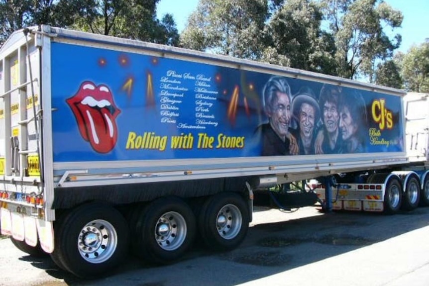 A truck painted with the heads of the Rolling Stones with the words "Rolling with The Stones"