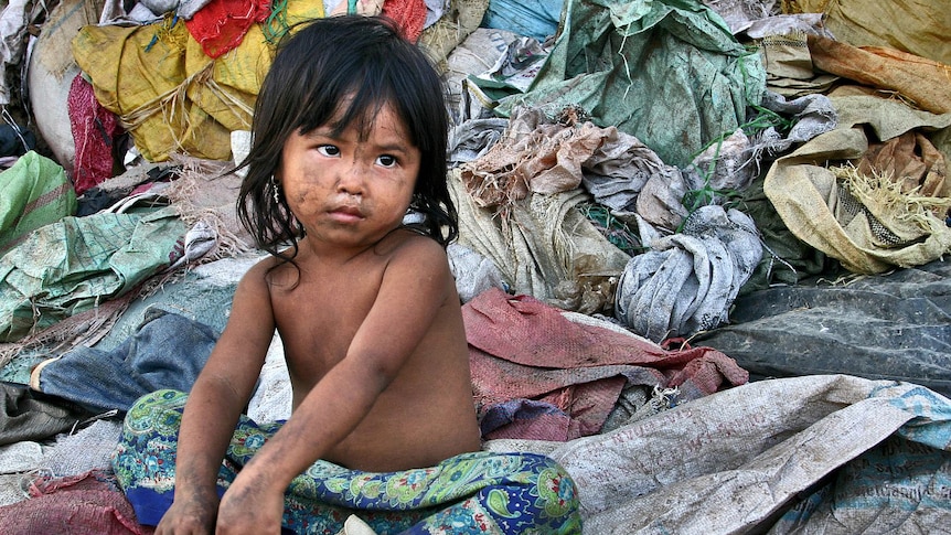 Young girl sits at a Cambodian rubbish dump in Siem Reap