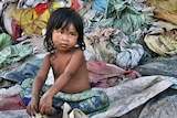 Young girl sits at a Cambodian rubbish dump in Siem Reap