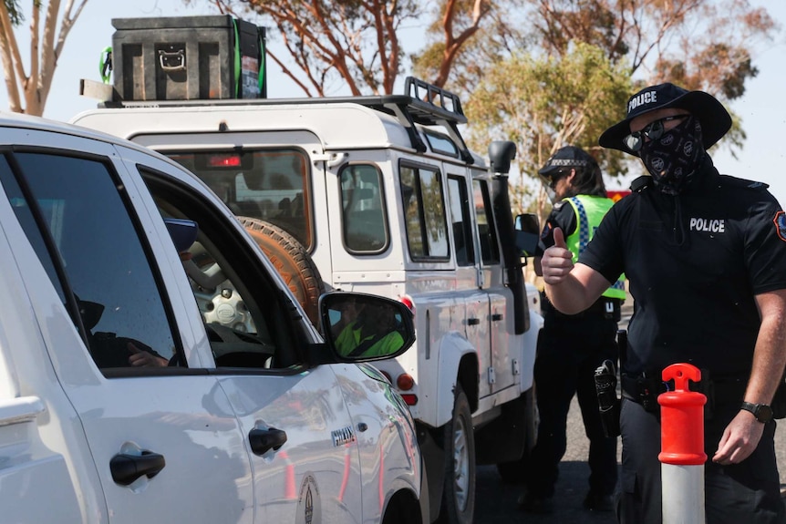 Cars line up at a police checkpoint.