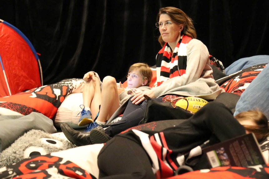 Saints fans watch the game on the big screen — with no sound — inside the sensory room.