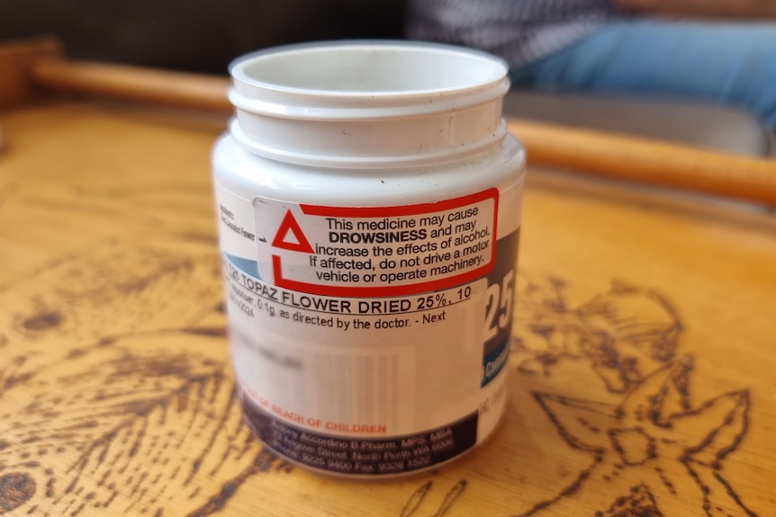 A medicine bottle with a tag warning the medicine may cause drowsiness