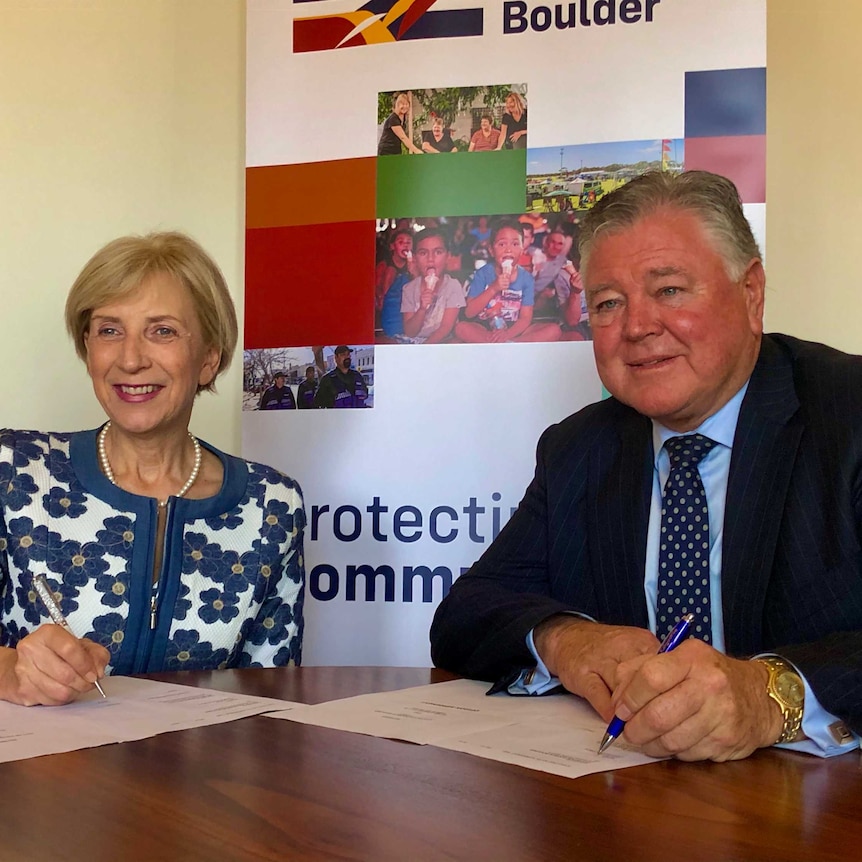 Lynas CEO Amanda Lacaze and City of Kalgoorlie-Boulder CEO John Walker sign a document.