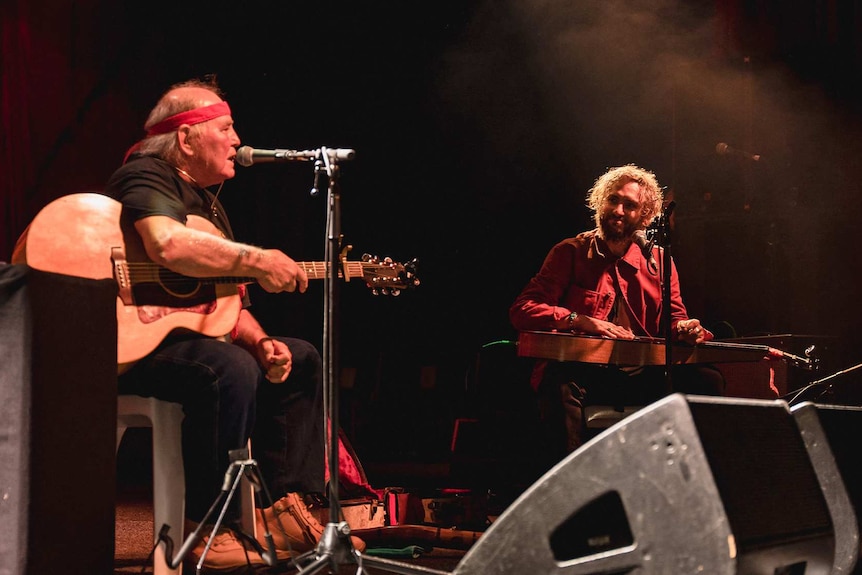Kev Carmody and John Butler on stage with guitars and microphones at Bluesfest 2022