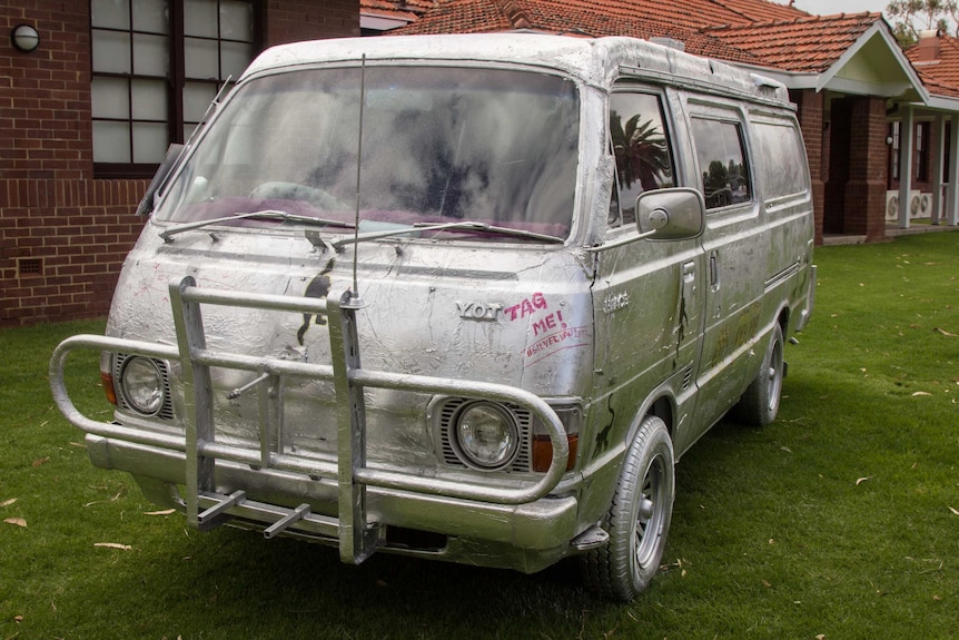 A van covered in silver foil with the words 'tag me' on it.