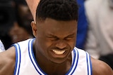 Zion Williamson grimaces as he does the splits, with his left trainer split open