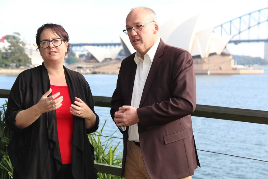 Penny Sharpe and Luke Foley standing in front of the Opera House and part of the Harbour Bridge.