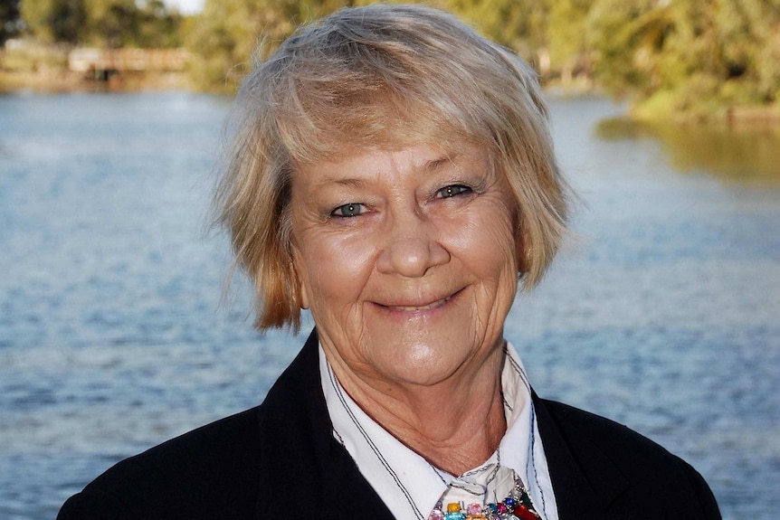 Jan Clifford smiles at the camera wearing a business suit.