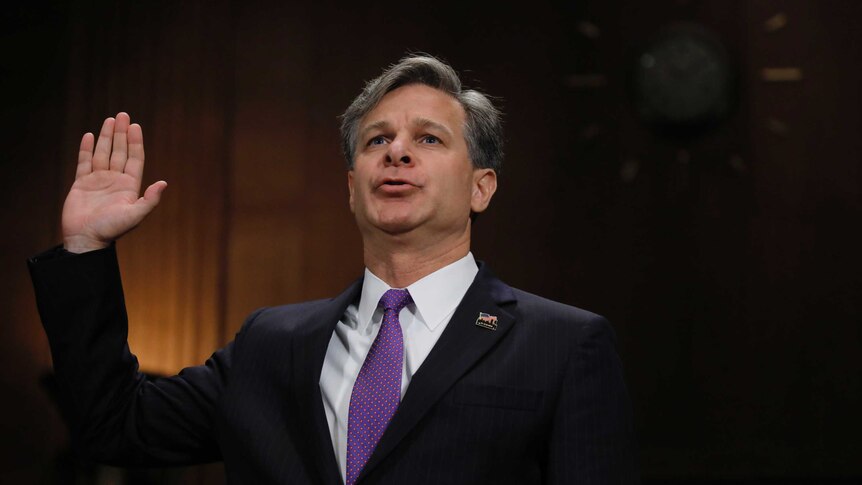 Christopher Wray raises his hand as he is sworn in prior to testifying.