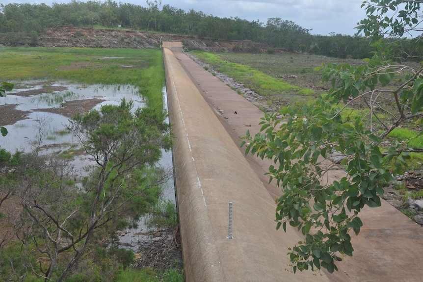 The Darwin River Dam spillway is seen with little water on either side.