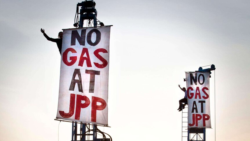 Protesters above drill rigs at gas hub north of Broome with signs
