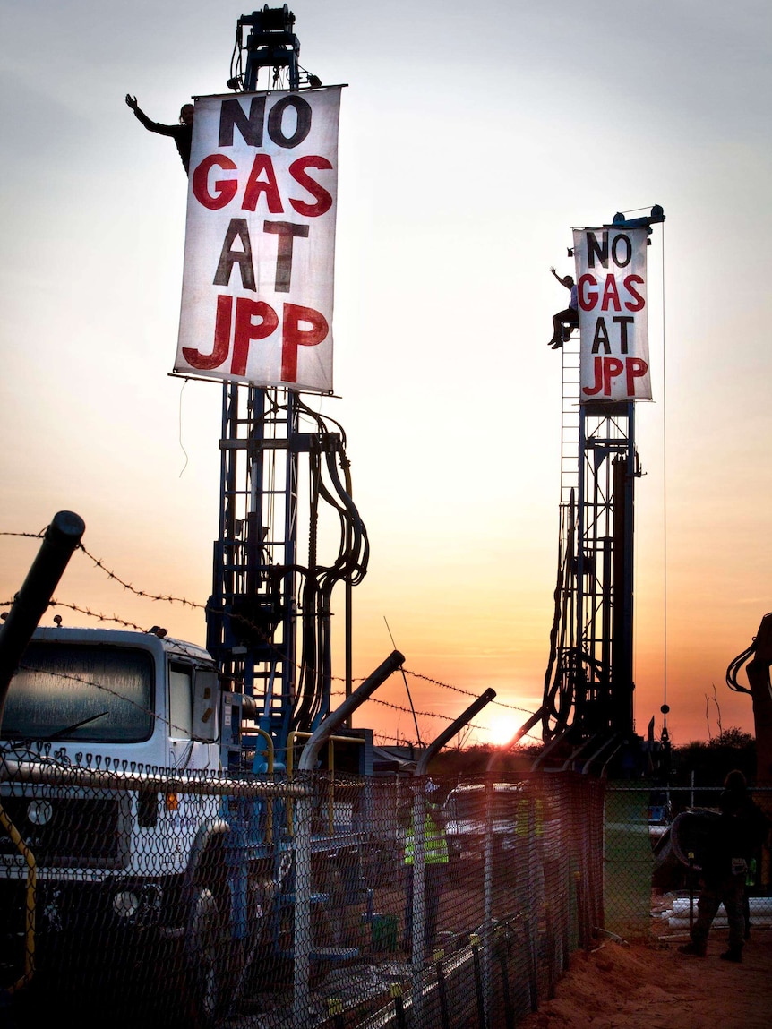 Evan Dowlings and Frances Myles sit atop two Woodside drill rigs at James Price Point.