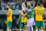 A group of Socceroos applaud the fans and thank them after the end of their final World Cup game.