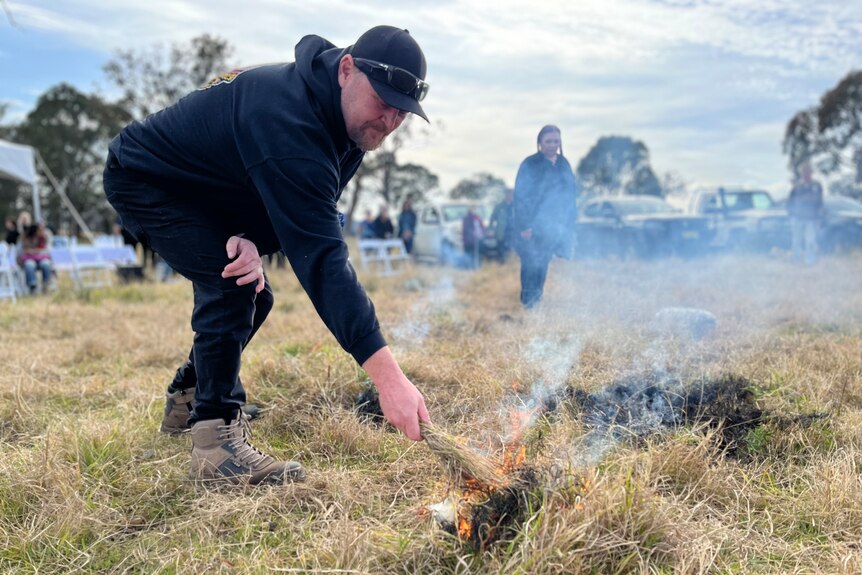 A man conducting cultural burning in grassland.
