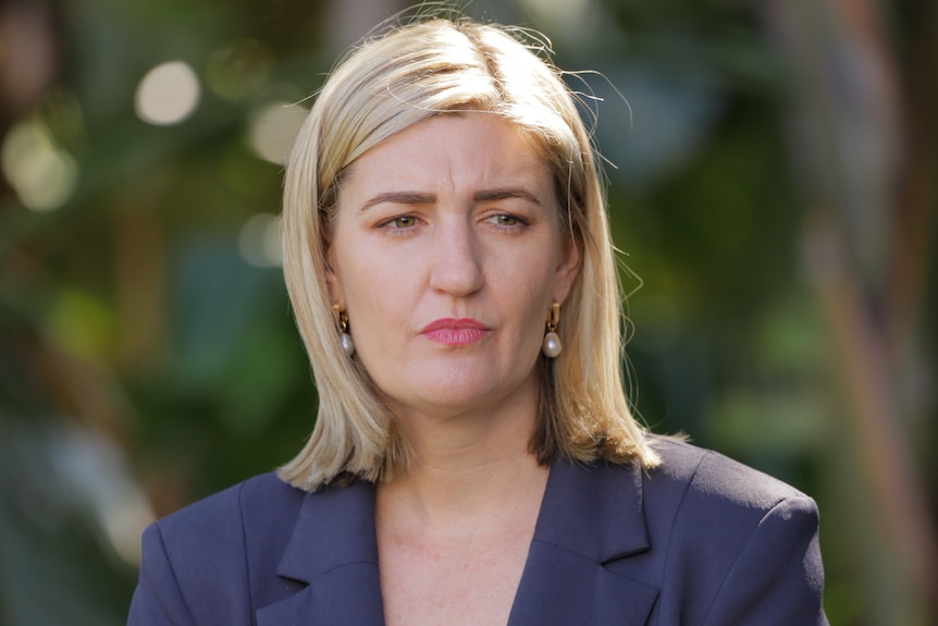 A close-up of a blond woman looking serious