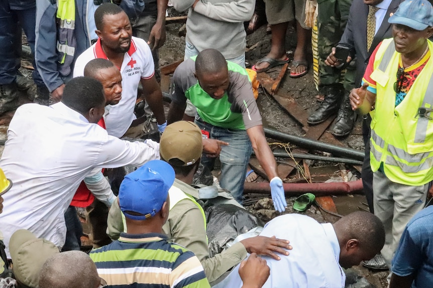 people search through dirt and debris for bodies from the small plane crash in Congo