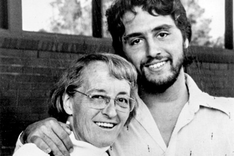 A black and white photo of Elisabeth and Ken standing side by side, smiling.