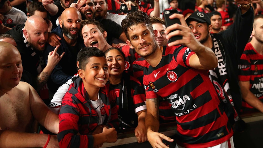 Man of the moment ... Dario Vidosic poses with Wanderers fans after securing victory in extra time