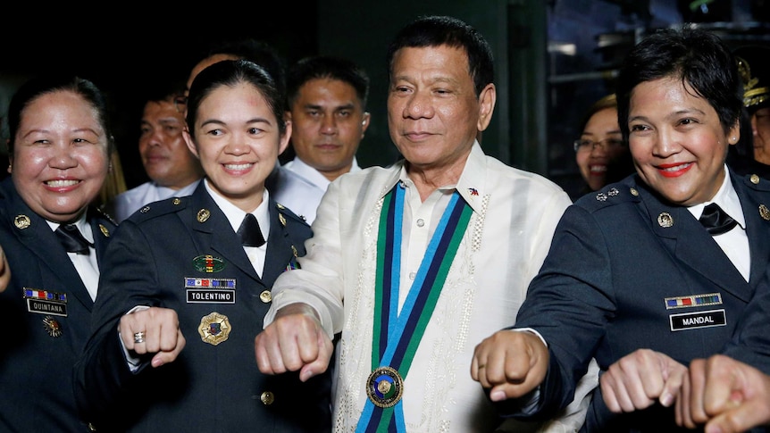 Duterte looks smug as he fist bumps with four female military officers