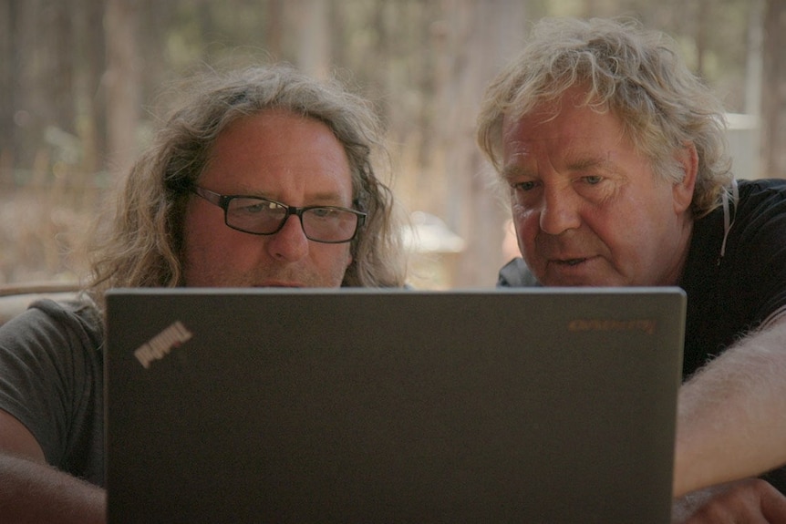 Neil Waters with film maker David Elliot-Jones looking at a laptop screen.