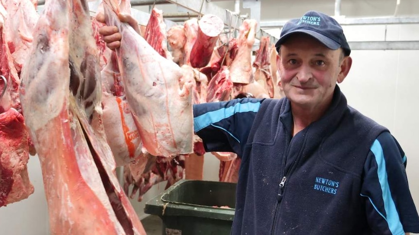 Man standing in a butcher shop