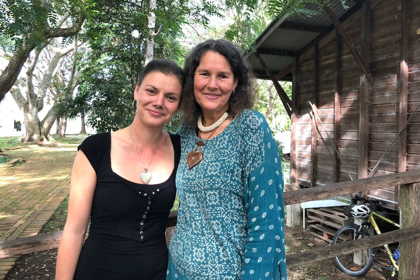 Two women standing on a ramp with trees in background