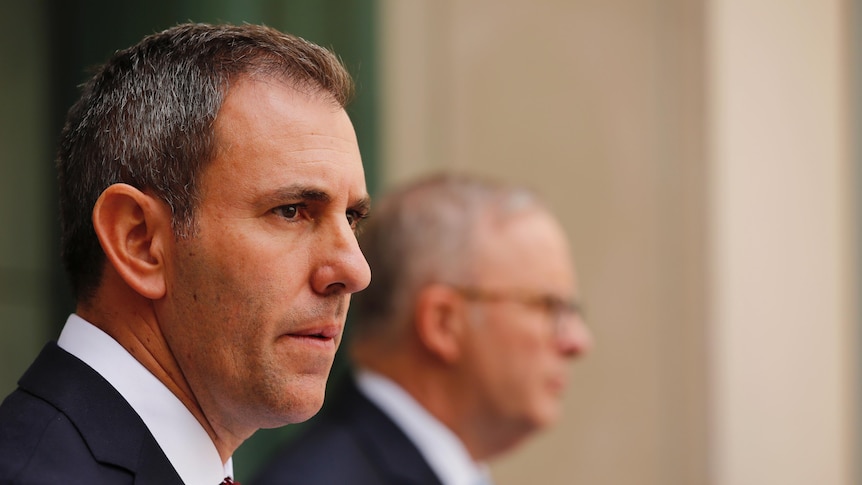 Jim Chalmers in the foreground in focus, with Anthony Albanese in the background out of focus, from the right hand side