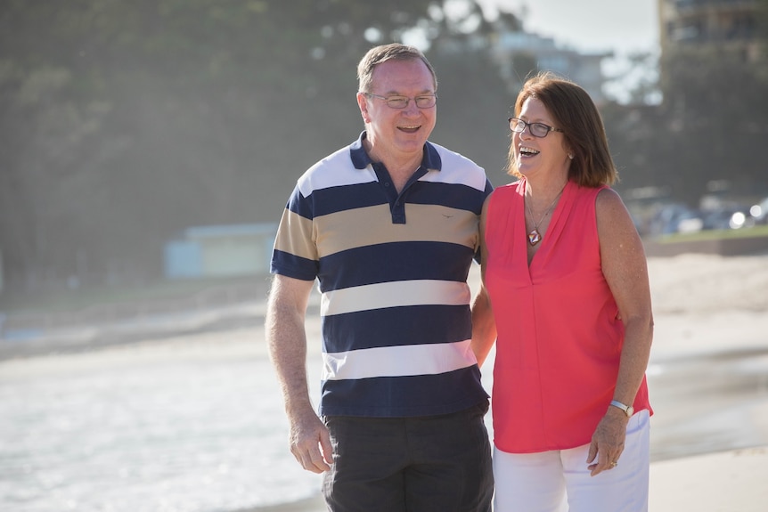 Man and woman walk along beach