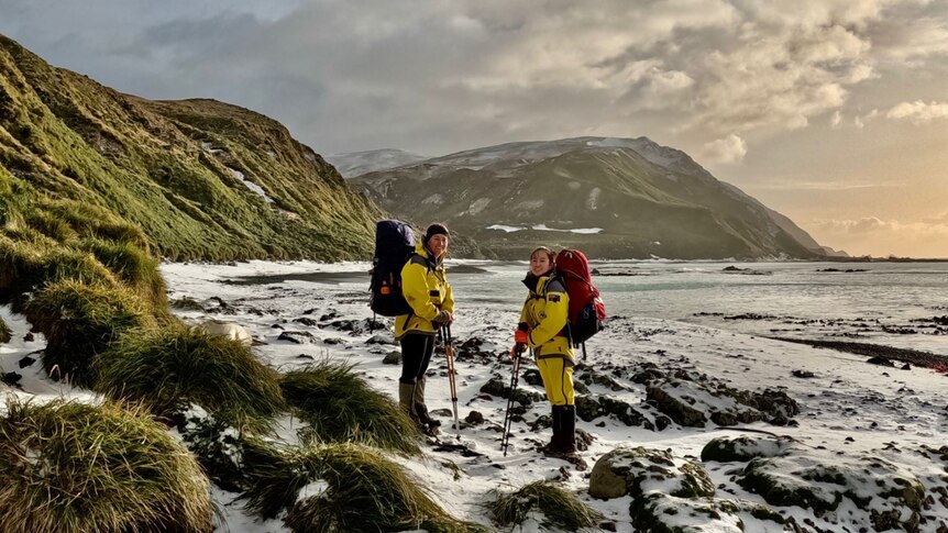Female expeditioners on a snow covered beach on a remote island.