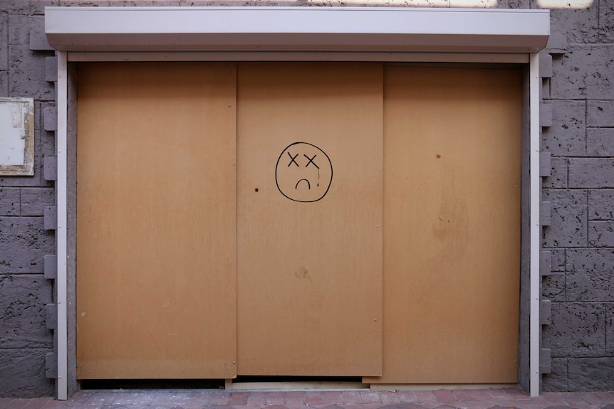A boarded up shop door in the Jull Street Mall