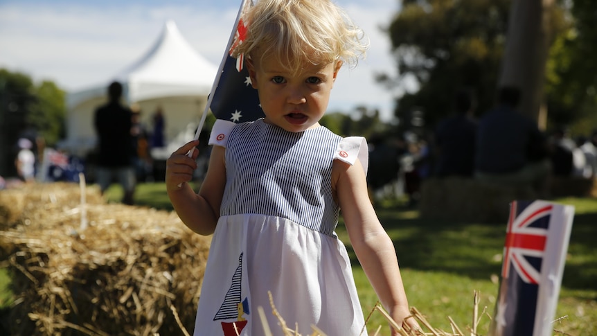 Two-year-old Grace Isler holds Australian flags