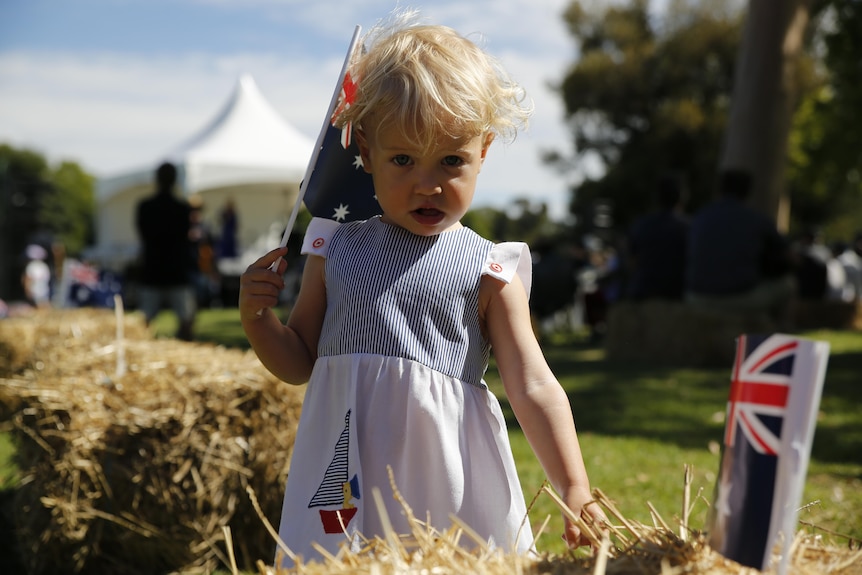 Two-year-old Grace Isler holds Australian flags