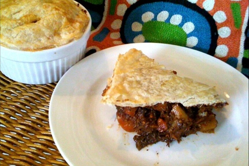 Slice of meat and vegetable pie on a white plate.