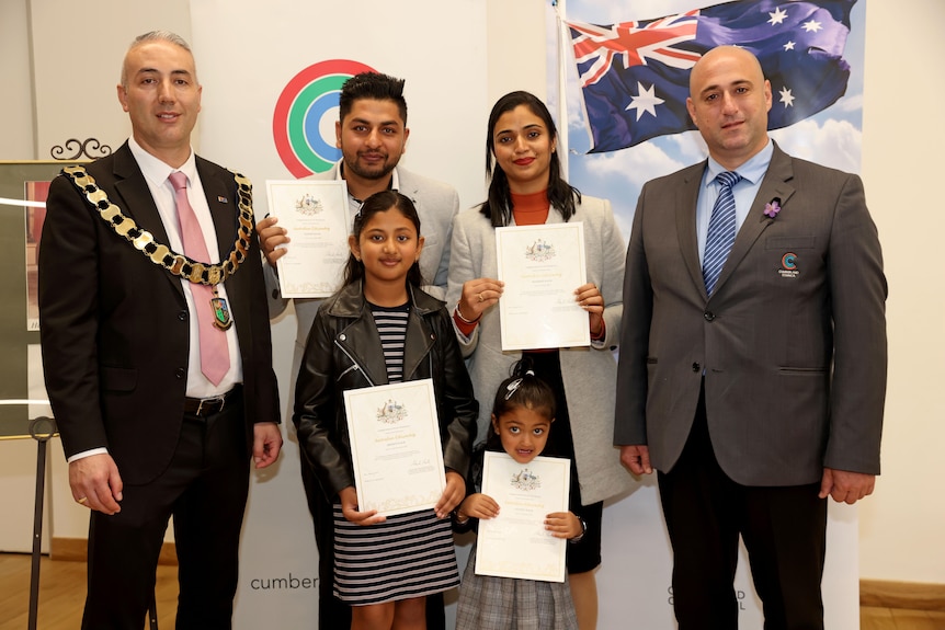 family forms a picture with Australian citizenship certificates