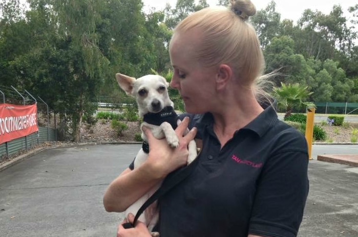 Woman (Helene Peck) holding a small dog in her arms