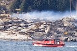 A rescue boat at work searching for survivors of a helicopter crash.