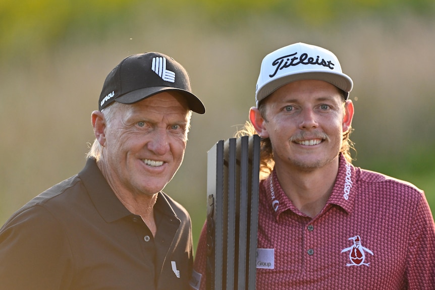 Norman and Smith pose with a black trophy.