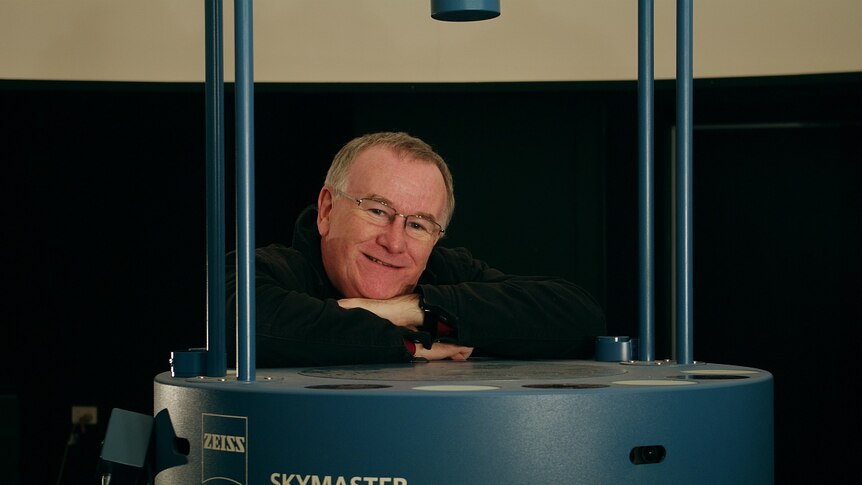 Astronomer Martin george leaning on the Launceston Planetarium projector