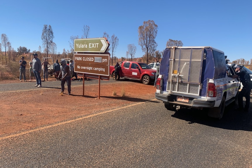 Members of the Mutitjulu Community Aboriginal Corporation attempt to blockade an entrance into Uluru-Kata Tjuta National Park.