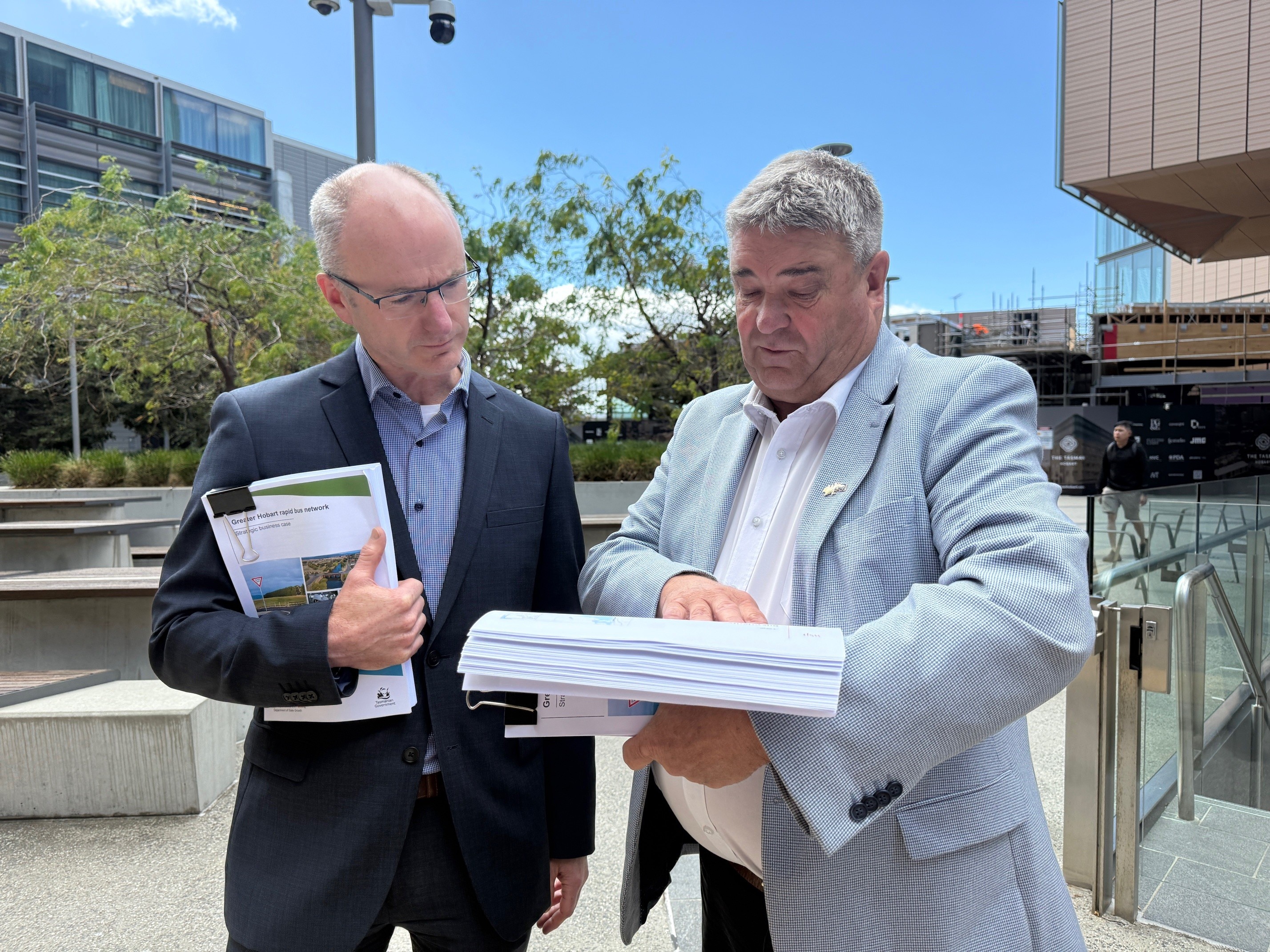 Dos hombres miran un documento.