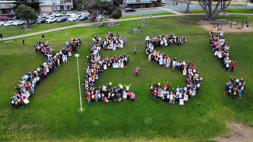 A crowd of Voice supporters form a human 'YES' near Cosy Corner Beach in Torquay