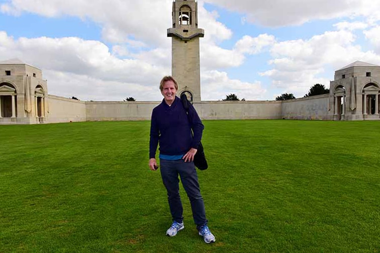 Man standing on the lawn in front of the Villers Bretonneux war monument