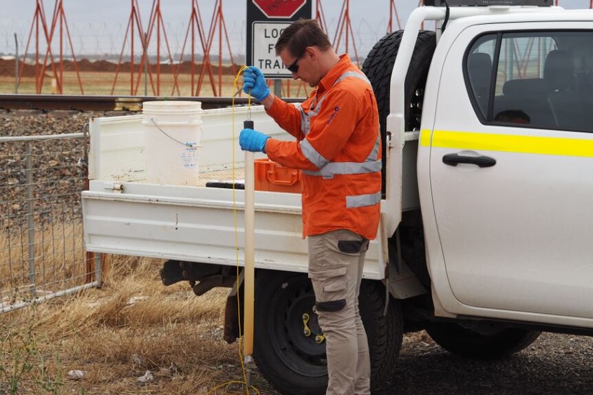 Worker testing for PFAS on Salisbury Council land next to the RAAF base