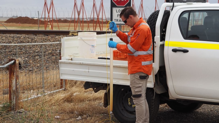 Worker testing for PFAS on Salisbury Council land next to the RAAF base