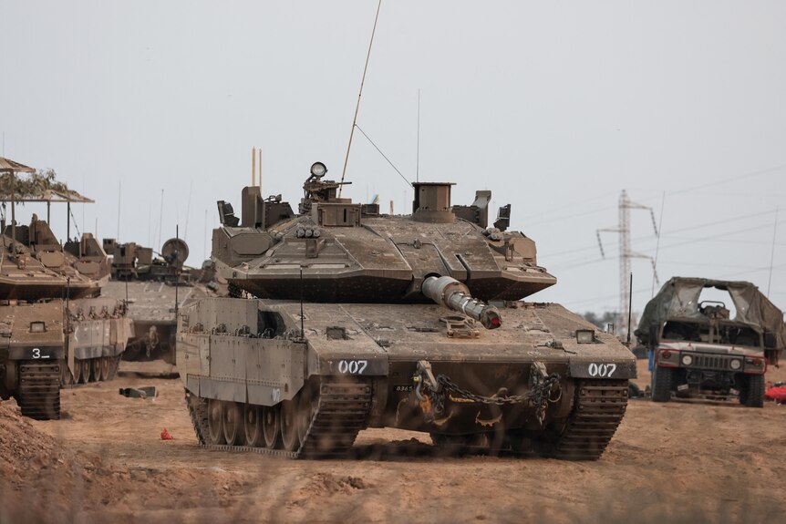 An Israeli tank and military vehicles are seen near Israel's border with the Gaza Strip.