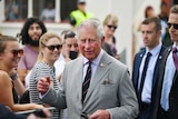 Prince Charles smiles as he walks through a crowd outside a church