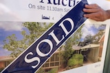 Auction sign on house covered with sold sticker
