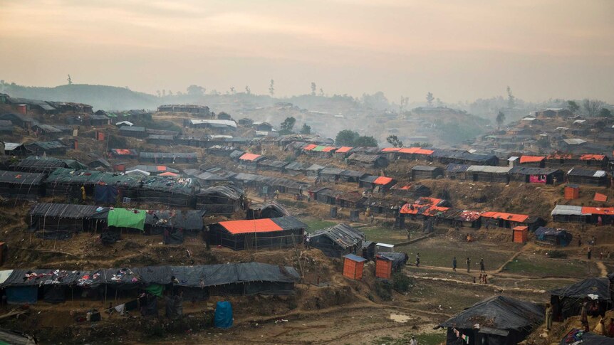 distant view of temporary houses lined up along a muddy ridge