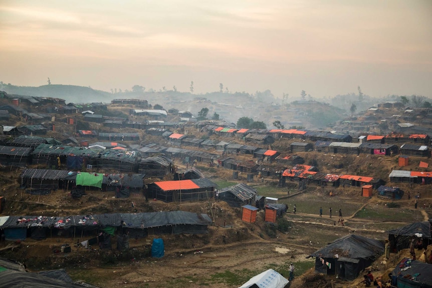 distant view of temporary houses lined up along a muddy ridge
